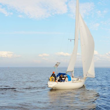 Açık denizde yelkenli yelkenli yelkenli. Gökyüzü açık, bulutlu. Yelkenlinin manzarası. Ulaşım, seyahat, spor, eğlence, boş zaman aktivitesi, yarış, yelkenli yarışı. Panorama, boşluğu kopyala