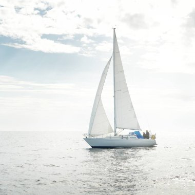 Açık denizde yelkenli yelkenli yelkenli. Gökyüzü açık, bulutlu. Yelkenlinin manzarası. Ulaşım, seyahat, spor, eğlence, boş zaman aktivitesi, yarış, yelkenli yarışı. Panorama, boşluğu kopyala