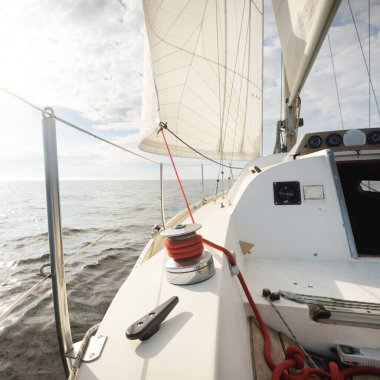 Günbatımında Baltık Denizi 'nde yelkenli yelkenli yelkenli. Kokpitten pruvaya, direğe ve yelkenlere bakın. Ulaşım, seyahat, gezi, spor, eğlence, boş zaman aktivitesi, yelkenli yarışı