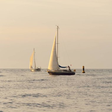 Baltık Denizi 'nde yelkenli bir yat. Gün batımı. Fırtınadan sonra dramatik bir gökyüzü, yumuşak güneş ışığı. Ulaşım, seyahat, seyahat, yat yarışı, spor, eğlence, eğlence, eğlence, yaşam tarzı, aile.