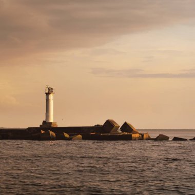 Fırtınadan sonra Baltık Denizi, yelkenli tekneden panoramik manzara. Deniz feneri. Dramatik gün batımı gökyüzü. Parlayan bulutlar, altın güneş ışığı. Idyllic deniz manzarası. Doğa, gezi, seyahat yerleri