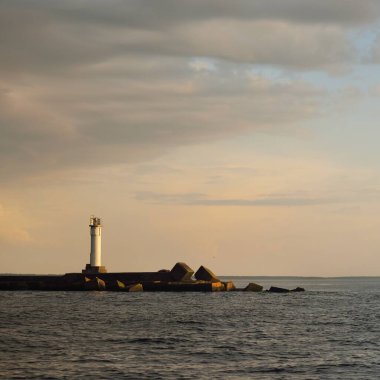 Fırtınadan sonra Baltık Denizi, yelkenli tekneden panoramik manzara. Deniz feneri. Dramatik gün batımı gökyüzü. Parlayan bulutlar, altın güneş ışığı. Idyllic deniz manzarası. Doğa, gezi, seyahat yerleri