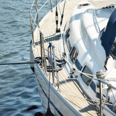 Limandaki bir rıhtıma demirlenmiş modern bir yat. Tahta meşe güvertesi, direği ve yelkenleri yukarıdan görüyor. Akdeniz 'de. Kiralık, gezici, eğlence, eğlence, eğlence, spor, yelkenli yarışı için özel bir gemi.