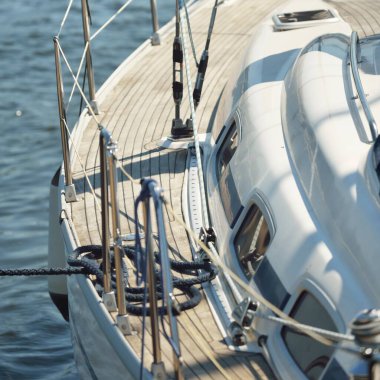 Limandaki bir rıhtıma demirlenmiş modern bir yat. Tahta meşe güvertesi, direği ve yelkenleri yukarıdan görüyor. Akdeniz 'de. Kiralık, gezici, eğlence, eğlence, eğlence, spor, yelkenli yarışı için özel bir gemi.