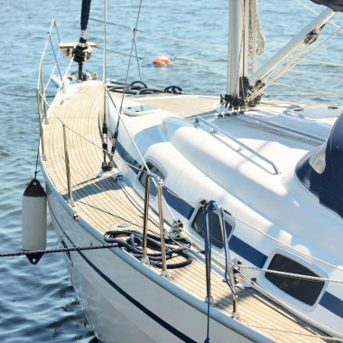 Limandaki bir rıhtıma demirlenmiş modern bir yat. Tahta meşe güvertesi, direği ve yelkenleri yukarıdan görüyor. Akdeniz 'de. Kiralık, gezici, eğlence, eğlence, eğlence, spor, yelkenli yarışı için özel bir gemi.