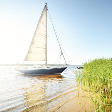 Kumlu kıyıya demirli mavi şalopeli yat (kumsalda otlarla kaplanmış). İsveç 'te, Avrupa' da. Doğa, yaz tatilleri, eğlence, gezi, spor, ulaşım, eko-turizm