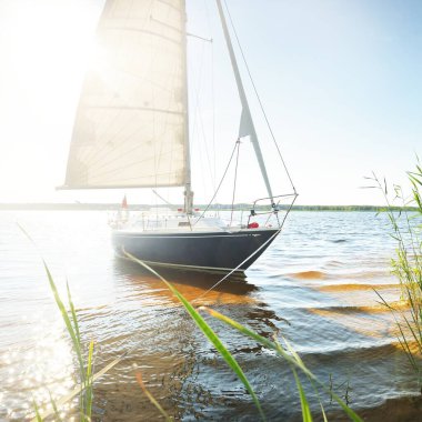 Kumlu kıyıya demirli mavi şalopeli yat (kumsalda otlarla kaplanmış). İsveç 'te, Avrupa' da. Doğa, yaz tatilleri, eğlence, gezi, spor, ulaşım, eko-turizm