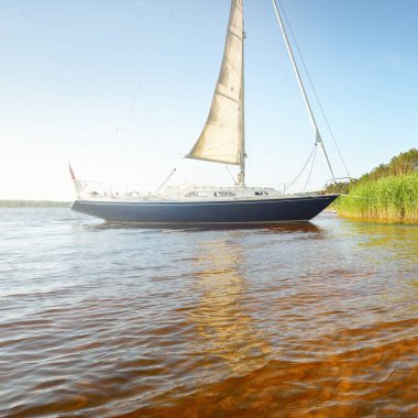 Kumlu kıyıya demirli mavi şalopeli yat (kumsalda otlarla kaplanmış). İsveç 'te, Avrupa' da. Doğa, yaz tatilleri, eğlence, gezi, spor, ulaşım, eko-turizm