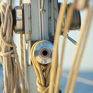 Açık bir günde beyaz yelkenli tekneyle denize açılmak. Güverteden direğe kadar bir manzara. Ekipmanlar, ipler, yakın çekim. Ulaşım, seyahat, gezi, eğlence, eğlence, eğlence, yat yarışı.