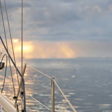 Fırtınadan sonra Baltık Denizi, yelkenli tekneden panoramik manzara. Dramatik gün batımı gökyüzü. Parlayan bulutlar, altın güneş ışığı. Idyllic deniz manzarası. Doğa, gezi, seyahat yerleri