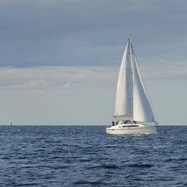 Günbatımında Baltık Denizi 'nde yelkenli yelkenli yelkenli. Fırtınadan sonra açık gökyüzü, yumuşak güneş ışığı. Ulaşım, seyahat, gezi, spor, eğlence, boş zaman aktivitesi, yarış, yelkenli yarışı