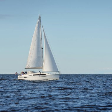 Baltık Denizi 'nde yelkenli bir yat. Gün batımı. Fırtınadan sonra dramatik bir gökyüzü, yumuşak güneş ışığı. Ulaşım, seyahat, seyahat, yat yarışı, spor, eğlence, eğlence, eğlence, yaşam tarzı, aile.