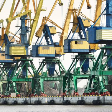 Riga, Letonya 'daki modern kömür terminali. Vinçler yakın plan. Baltık Denizi. Nakliye, lojistik, küresel iletişim, ekonomi, iş, endüstri, tedarik, özel ekipman. Şehir manzarası
