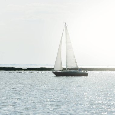 Günbatımında Baltık Denizi 'nde yelkenli yelkenli yelkenli. Fırtınadan sonra açık gökyüzü, yumuşak güneş ışığı. Deniz feneri. Ulaşım, seyahat, gezi, spor, eğlence, boş zaman aktivitesi, yarış, yelkenli yarışı