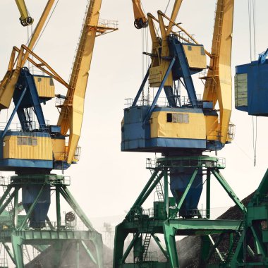 Riga, Letonya 'daki modern kömür terminali. Vinçler yakın plan. Baltık Denizi. Nakliye, lojistik, küresel iletişim, ekonomi, iş, endüstri, tedarik, özel ekipman. Şehir manzarası