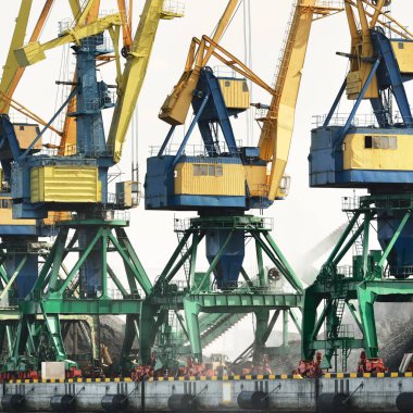 Riga, Letonya 'daki modern kömür terminali. Vinçler yakın plan. Baltık Denizi. Nakliye, lojistik, küresel iletişim, ekonomi, iş, endüstri, tedarik, özel ekipman. Şehir manzarası