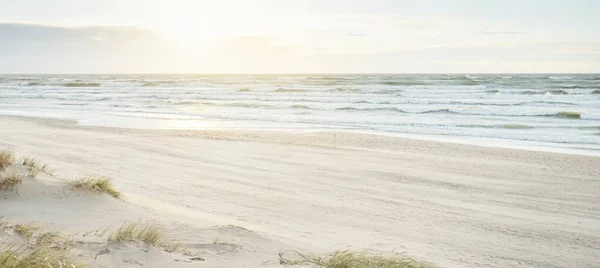 Baltic sea shore at sunset. Clear sunset sky, glowing clouds. Idyllic landscape. Nature, vacations, recreation. eco tourism. Panoramic view