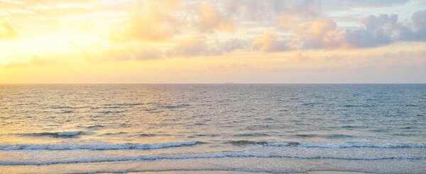 Panoramic view from the Baltic sea shore at sunset. Dramatic cloudscape, glowing clouds, golden sunlight after the storm. Nature, environment, climate change, fickle weather