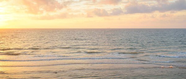 Panoramic view from the Baltic sea shore at sunset. Dramatic cloudscape, glowing clouds, golden sunlight after the storm. Nature, environment, climate change, fickle weather