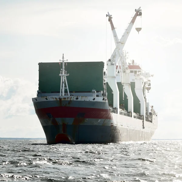 Large modern general cargo crane ship sailing in an open sea. Freight transportation, nautical vessel, logistics, global communications, economy, business, industry, worldwide shipping. Panoramic view