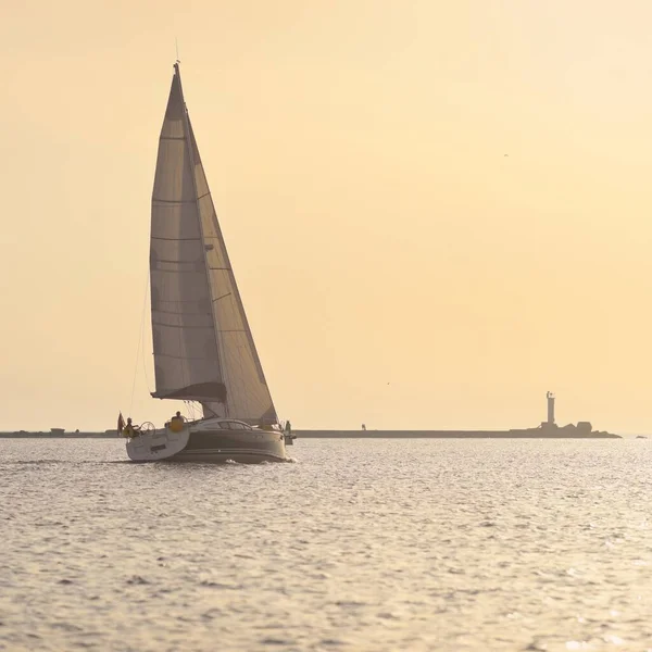 Günbatımında Baltık Denizi 'nde yelkenli yelkenli yelkenli. Fırtınadan sonra gökyüzü açık, altın güneş ışığı. Ulaşım, seyahat, gezi, spor, eğlence, boş zaman aktivitesi, yarış, yelkenli yarışı