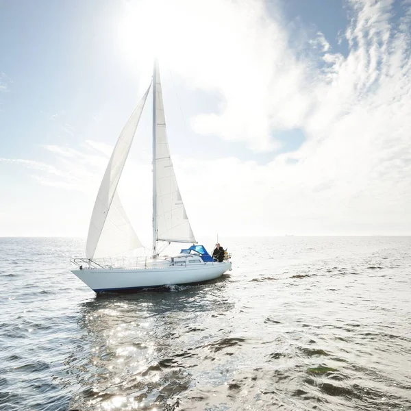 Açık denizde yelkenli yelkenli yelkenli. Gökyüzü açık, bulutlu. Yelkenlinin manzarası. Ulaşım, seyahat, spor, eğlence, boş zaman aktivitesi, yarış, yelkenli yarışı. Panorama, boşluğu kopyala