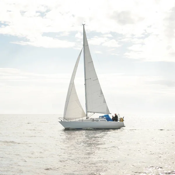 Açık denizde yelkenli yelkenli yelkenli. Gökyüzü açık, bulutlu. Yelkenlinin manzarası. Ulaşım, seyahat, spor, eğlence, boş zaman aktivitesi, yarış, yelkenli yarışı. Panorama, boşluğu kopyala