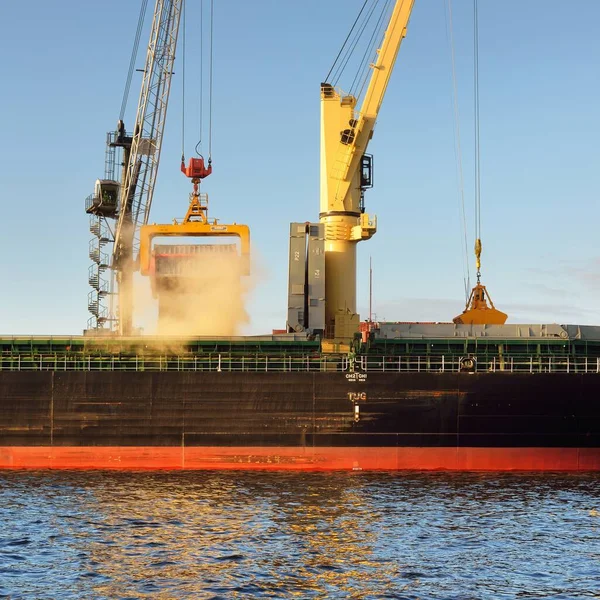 Liman terminalinde vinçleri yükleyen büyük bir yük gemisi (179 metre uzunluğunda). Baltık Denizi. Nakliye, lojistik, küresel iletişim, ekonomi, ticaret, sanayi, arz