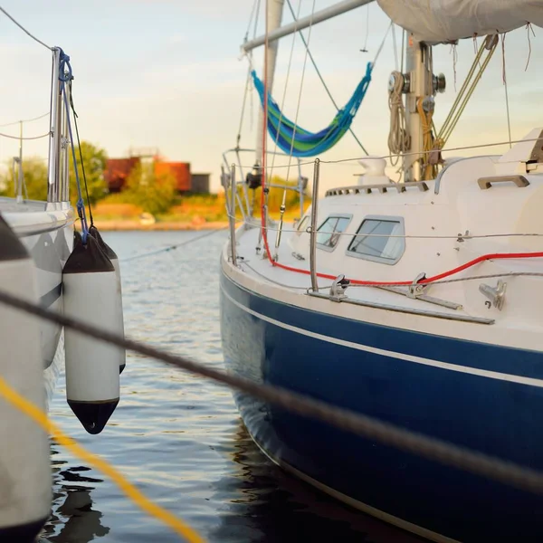 Yelkenliler açık bir yaz gününde yat limanındaki bir rıhtıma demirlediler. Tekne çamurlukları yakın plan. Ekipman, ulaşım, eğlence, tatil, boş zaman aktivitesi, spor, gezi, yaşam tarzı