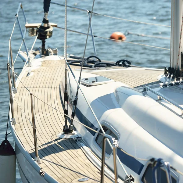 Modern charter yacht moored to a pier in marina. Top down view of the wooden teak deck, mast and sails. Mediterranean sea. Private vessel for rent, cruise, recreation, leisure activity, sport, regatta