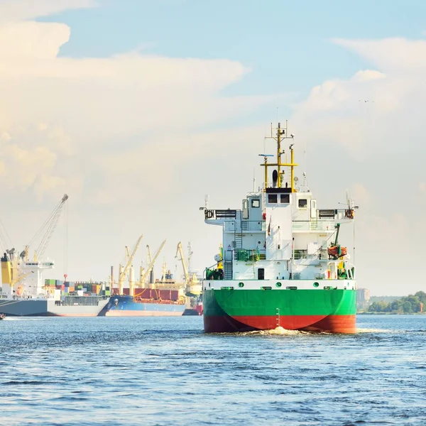 大型绿色散装货船日落时抵达货运站 船和起重机在后面 戏剧化的云雾 货物运输 全球通信 — 图库照片