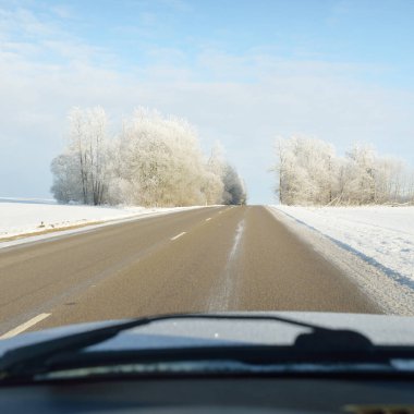 Karla kaplı orman ve kırsal alanda boş otoyol (asfalt yol). Kar sürükleniyor. Avrupa. Doğa, Noel tatilleri, uzak yerler, kış lastikleri, tehlikeli sürüş konsepti