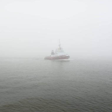 Kalın bir siste römorkör. Baltık Denizi. Kış deniz manzarası. Nakliye, deniz taşımacılığı, lojistik, sanayi, ticaret, ekonomi