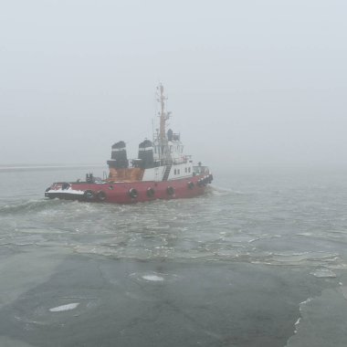 Kalın bir siste römorkör. Baltık Denizi. Kış deniz manzarası. Nakliye, deniz taşımacılığı, lojistik, sanayi, ticaret, ekonomi