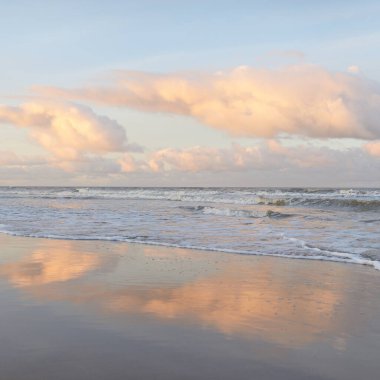 Fırtınadan sonra gün batımında Baltık Denizi. Dramatik gökyüzü, parlayan bulutlar, dofty altın güneş ışığı, dalgalar, fışkıran su. Resimli panoramik manzara. Doğa, çevre, ekoloji