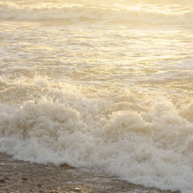 Fırtınadan sonra Baltık kıyıları. Gün batımı, yumuşak güneş ışığı. Su yüzeyi dokusu, çarpan dalgalar, sıçramalar, köpük. Resimli panoramik manzara. Idyllic deniz manzarası. Doğa, çevre, ekoloji temaları