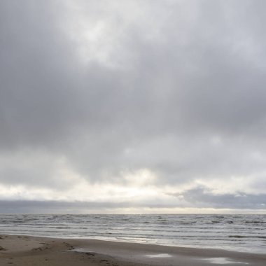 Fırtınadan sonra Baltık Denizi. Yumuşak günbatımı ışığı, çarpıcı parlayan bulutlar. Deniz manzarası, bulutlar, doğa. Panoramik manzara. Ekoloji, iklim değişikliği, hava durumu
