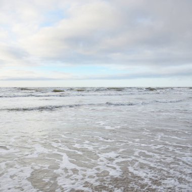Fırtınadan sonra Baltık Denizi. Yumuşak günbatımı ışığı, çarpıcı parlayan bulutlar. Deniz manzarası, bulutlar, doğa. Panoramik manzara. Ekoloji, iklim değişikliği, hava durumu
