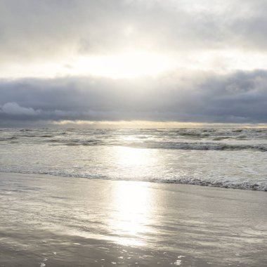 Fırtınadan sonra Baltık Denizi. Yumuşak günbatımı ışığı, çarpıcı parlayan bulutlar. Deniz manzarası, bulutlar, doğa. Panoramik manzara. Ekoloji, iklim değişikliği, hava durumu