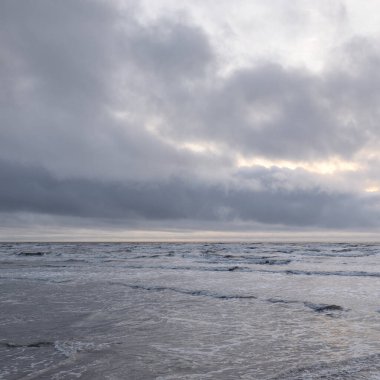 Fırtınadan sonra Baltık Denizi. Yumuşak günbatımı ışığı, çarpıcı parlayan bulutlar. Deniz manzarası, bulutlar, doğa. Panoramik manzara. Ekoloji, iklim değişikliği, hava durumu