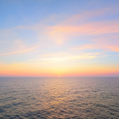 Gün batımında Baltık Denizi. Açık gökyüzü, mavi ve pembe parlayan bulutlar, yumuşak altın güneş ışığı. Su yüzeyi dokusu. Deniz manzarası, bulutlar, doğa gibi hayali görüntüler. Panoramik yaşam