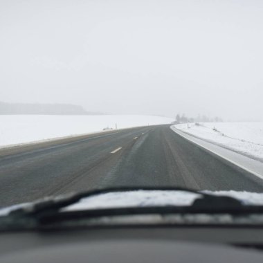 Karla kaplı orman ve kırsal alanda boş otoyol (asfalt yol). Kar fırtınası, kar yağışı. Avrupa. Doğa, Noel tatilleri, uzak yerler, kış lastikleri, tehlikeli sürüş konsepti