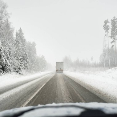Boş otoyol (asfalt yol) karla kaplı ormanın içinden, kırsal alanda. Arabadan bak. Avrupa. Doğa, Noel tatilleri, uzak yerler, kış lastikleri, tehlikeli sürüş konsepti