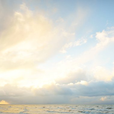 Fırtınadan sonra Baltık Denizi. Dramatik gökyüzü, parlayan bulutlar, yumuşak güneş ışığı. Dalgalar, su sıçratma. Resimli manzara, deniz manzarası, doğa. Panoramik görünüm