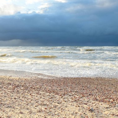 Fırtınadan sonra Baltık kıyıları (kum tepeleri, plaj). Dramatik gökyüzü, parlayan bulutlar. Resimli panoramik manzara. Doğa, çevre, ekoloji, eko-turizm, yürüyüş, keşif kavramları