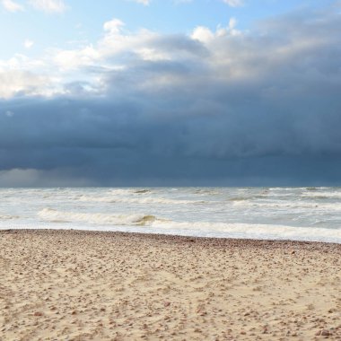 Fırtınadan sonra Baltık kıyıları (kum tepeleri, plaj). Dramatik gökyüzü, parlayan bulutlar. Resimli panoramik manzara. Doğa, çevre, ekoloji, eko-turizm, yürüyüş, keşif kavramları