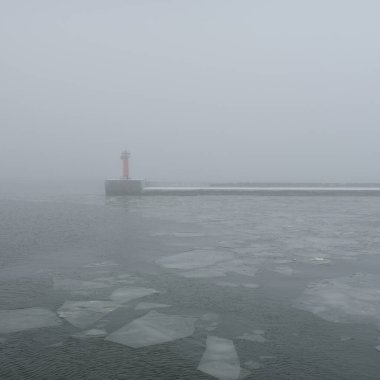 Sis içindeki Baltık Denizi. Dalgalar, su sıçratma, fırtına. Doğal dokular. Resimli panoramik monokrom manzarası, deniz manzarası. Doğa, çevre, sert hava, tehlike