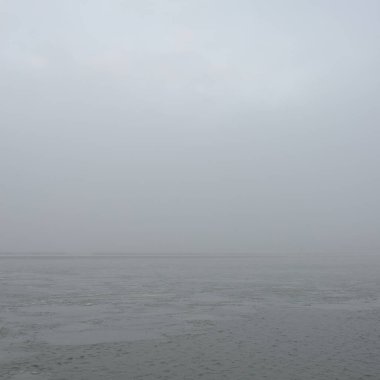 Sis içindeki Baltık Denizi. Dalgalar, su sıçratma, fırtına. Doğal dokular. Resimli panoramik monokrom manzarası, deniz manzarası. Doğa, çevre, sert hava, tehlike