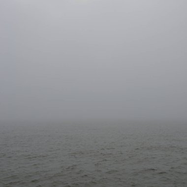 Sis içindeki Baltık Denizi. Dalgalar, su sıçratma, fırtına. Doğal dokular. Resimli panoramik monokrom manzarası, deniz manzarası. Doğa, çevre, sert hava, tehlike