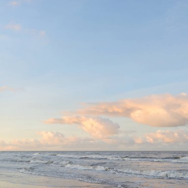 Kumlu bir sahilden (kum tepeleri) Baltık denizinin panoramik görüntüsü. Koyu bulutlu dramatik bir gökyüzü. Dalgalar, su sıçramaları. Idyllic deniz manzarası. Sıcak kış havası, iklim değişikliği, doğa. Danimarka